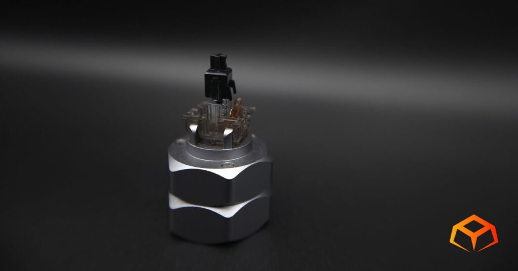 Macro shot of a Gateron Ink Black switch without the top housing, exposing the stem, spring, and leaf