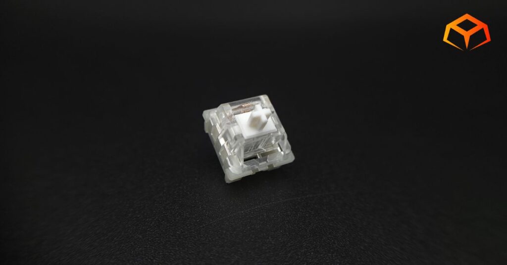 Macro shot of KTT Kang White linear switch with logo on top of the switch displayed