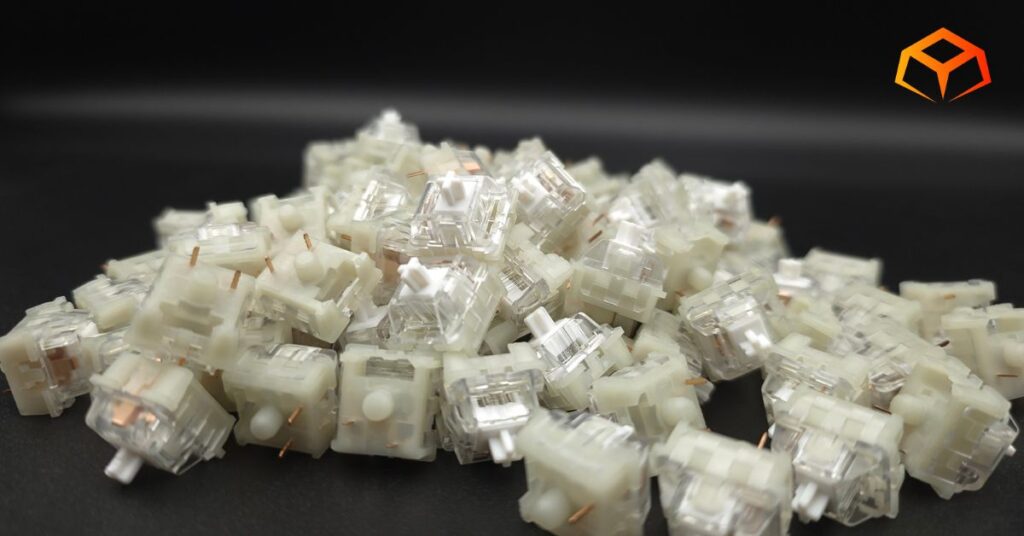 KTT Kang White linear switches piled up on top of each other with emphasis on the white stem of the switch in the center of the screen