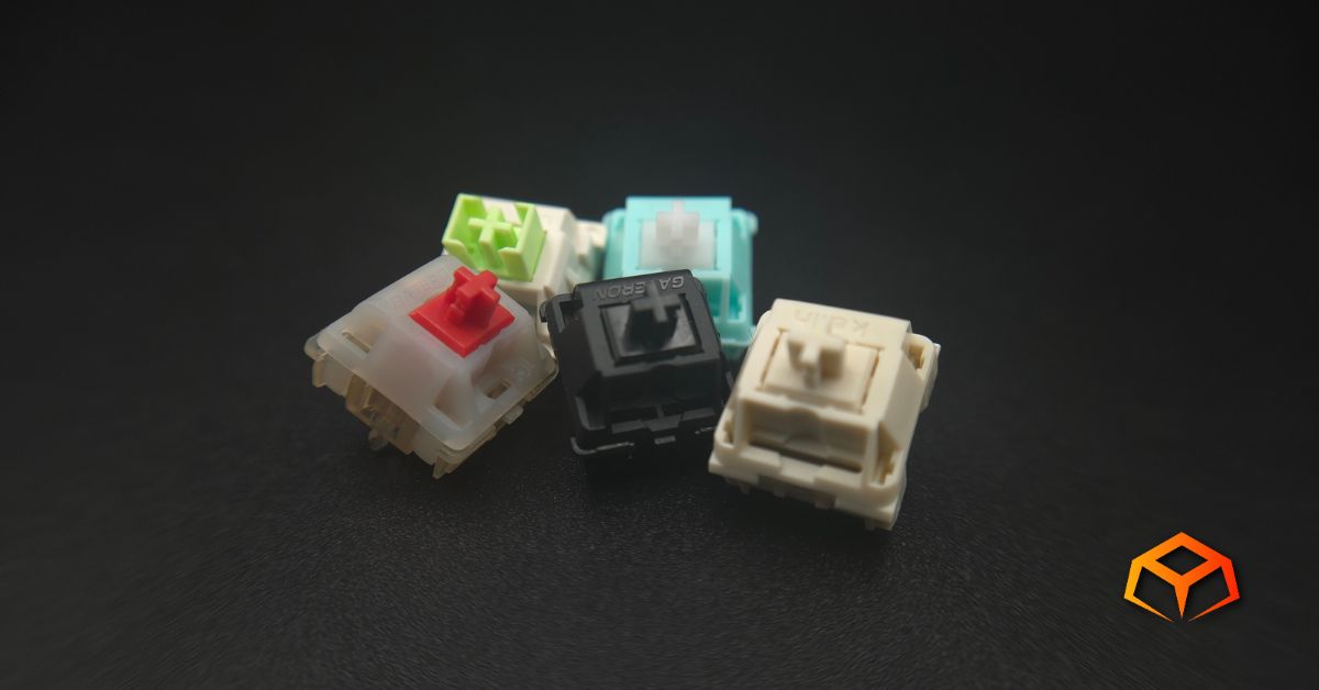 Macro shot of a single Gateron Oil King, Gateron Cream Soda, LEOBOG Reaper, Glorious Lynx, and NovelKeys Cream switches clumped together in the middle of the photo