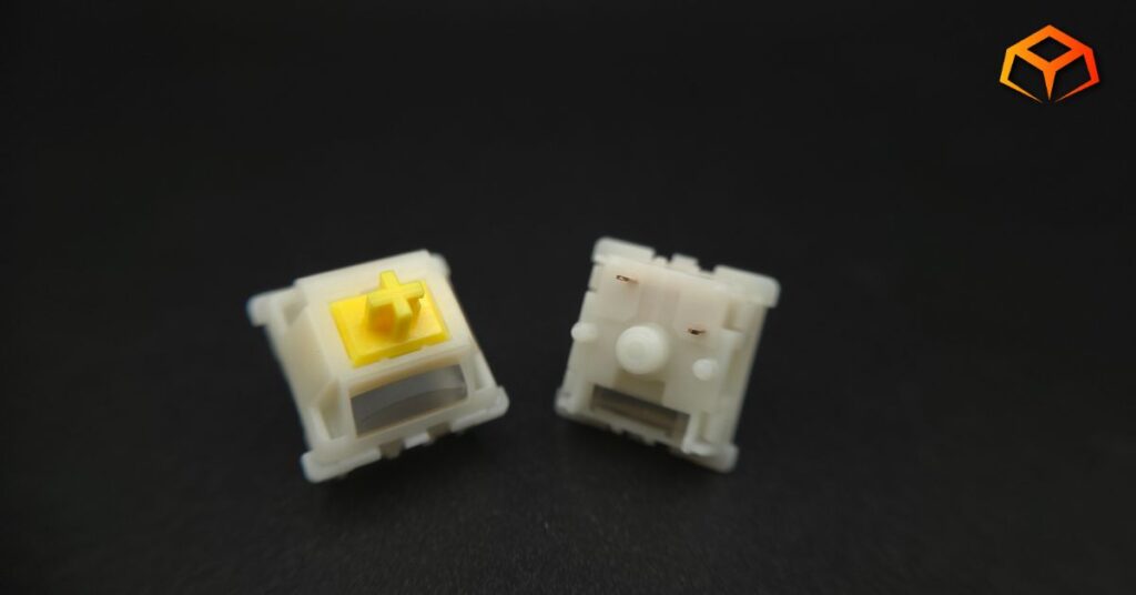 Macro shot of Gateron Milky Yellow Pro V3 switches side by side with the top and bottom showing